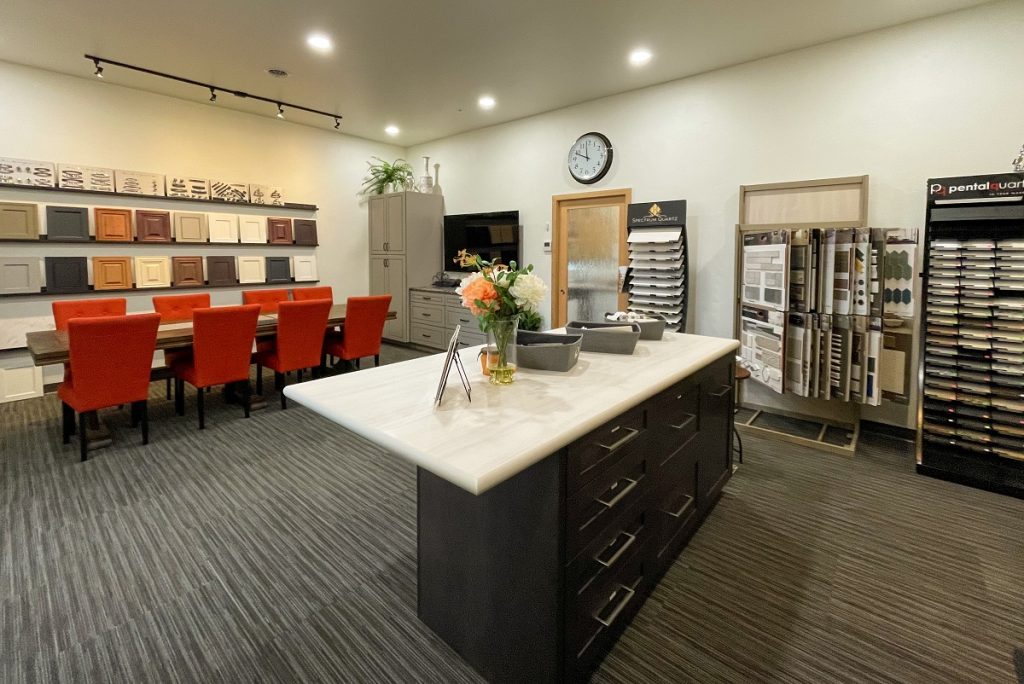 kitchen island with a white counter and dark wood inside a showroom