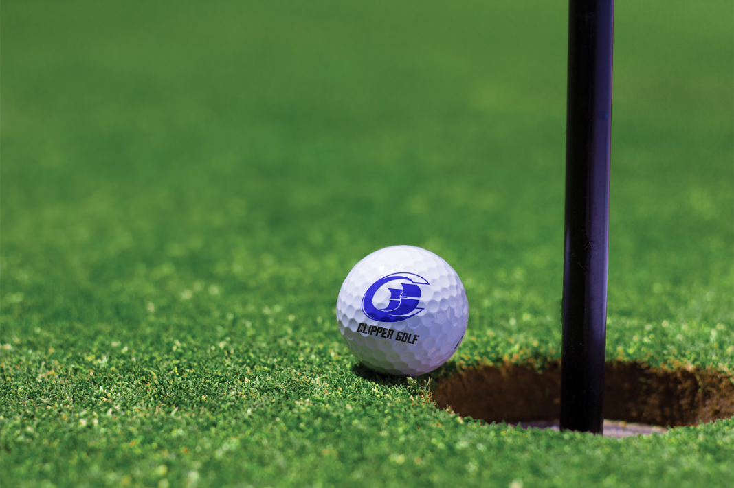 a golf ball with the SPSCC clipper logo out int sitting at the edge of a hole