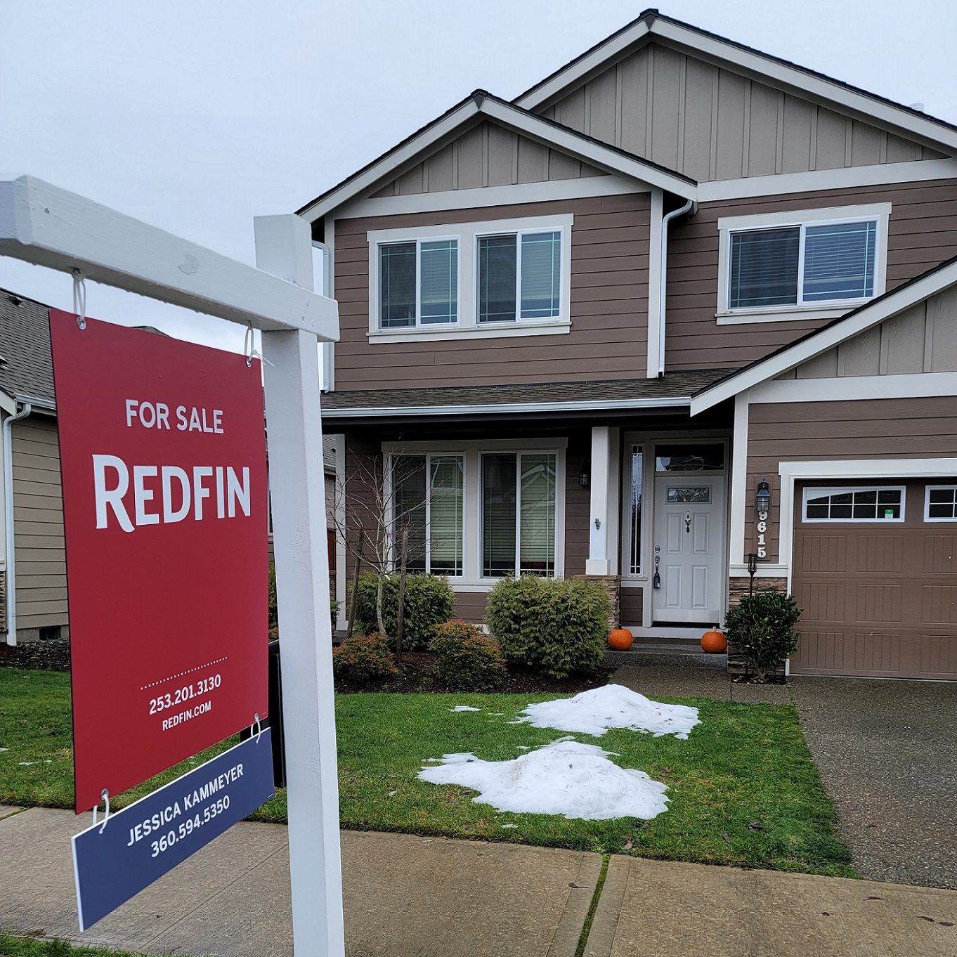 a brown two story house with a red, RedFin for sale sign out front
