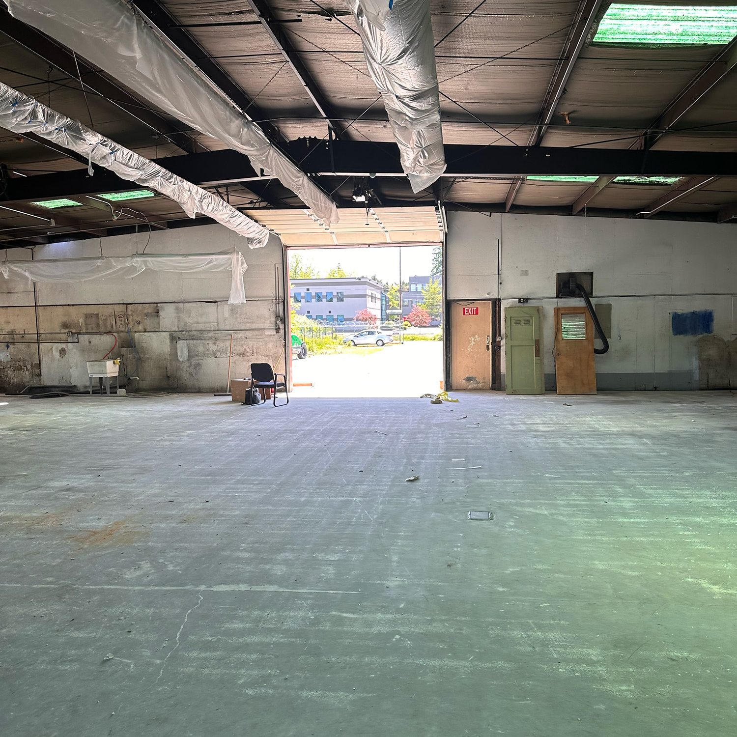 Large empty warehouse with doors open to the parking lot