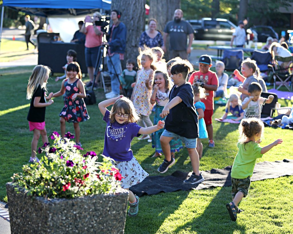 children in the grass listening to music