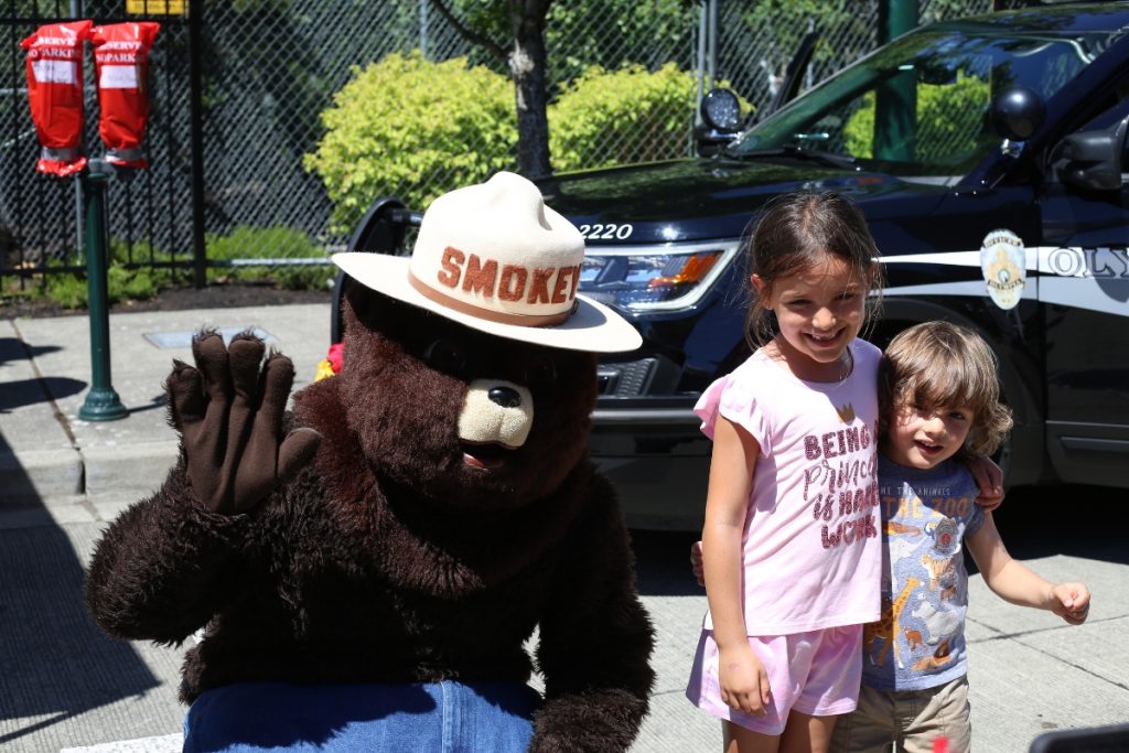 kid posing with Smokey the bear for a photo