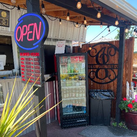 Jerk Juicy shack with order window, open sign, awning and drink fridge outfront