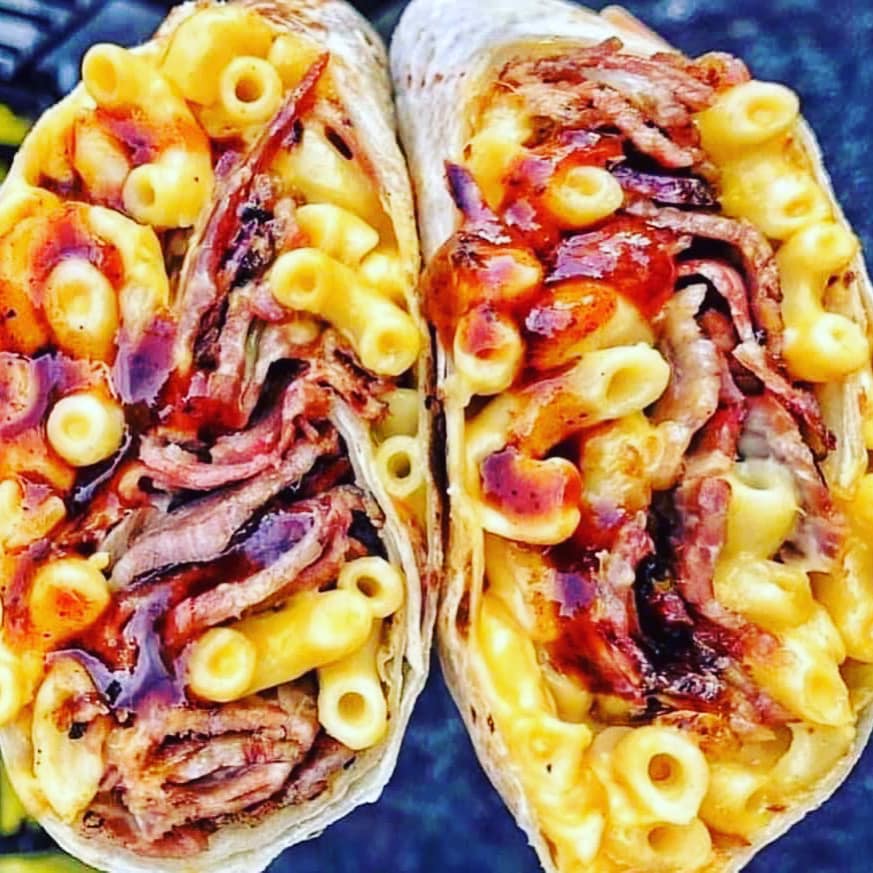 two burritos full of mac-and-cheese and brisket and barbecue sauce from Jerk Juicy