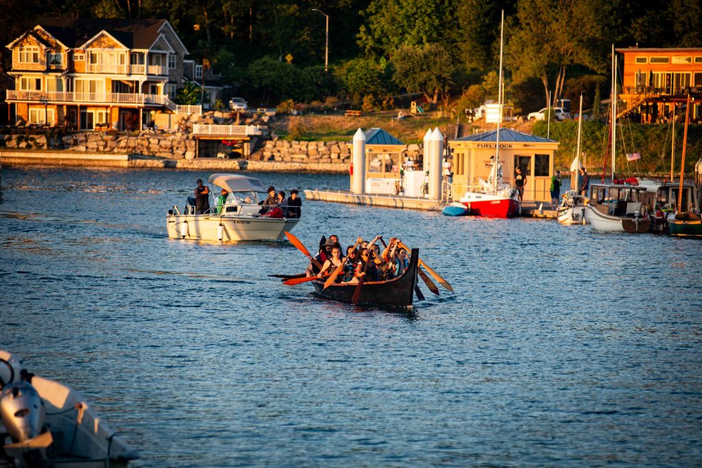 Squaxin Island Tribal members in a canoe by a dock in Puget Sound