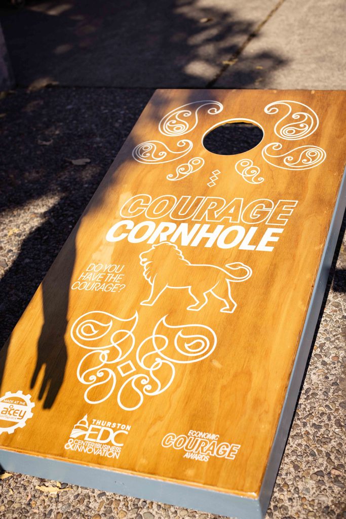 a cornhole board with a lion on it that says, 'Courage cornhole. Do you have the courage?'