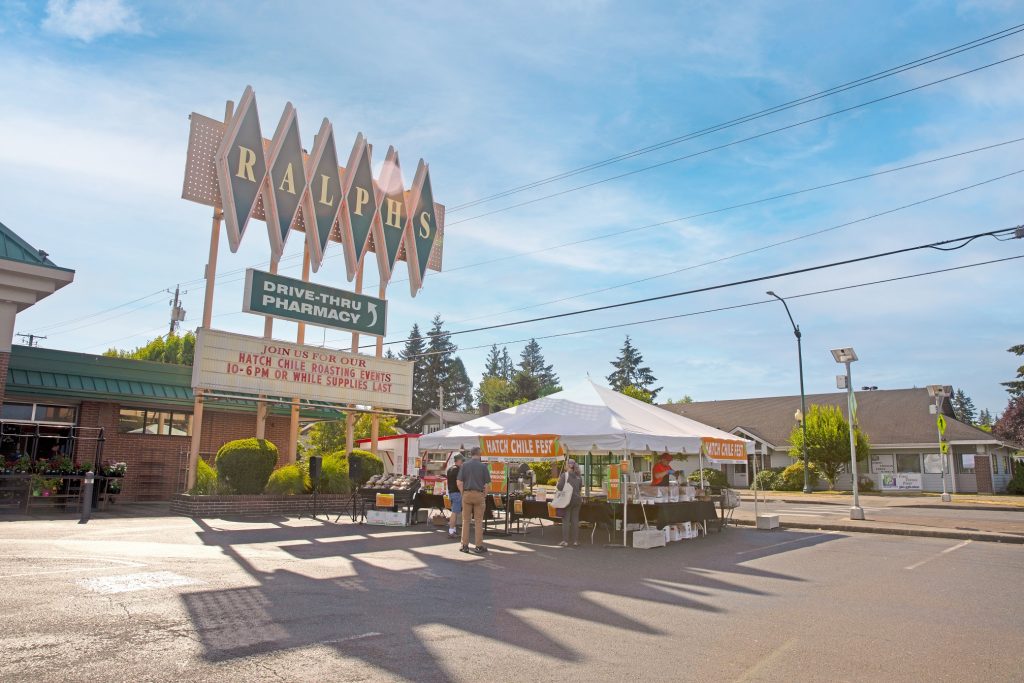 Large white tent with tables of roasting peppers underneath the Ralph's Thriftway sign