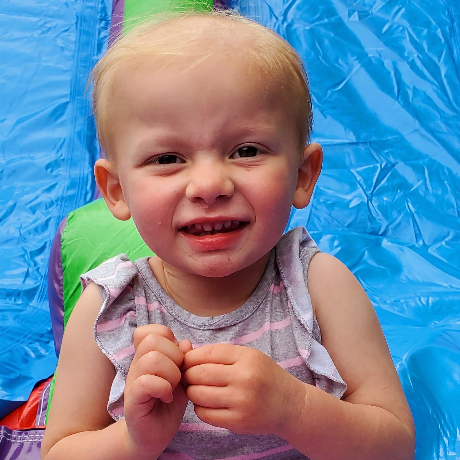 Little girl smiling for the camera on an inflatable toy