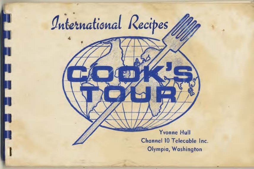 Cover of the 'Cook’s Tour: International Recipes' book with a blue lined photo of a globe with a fork across it and the title of the book