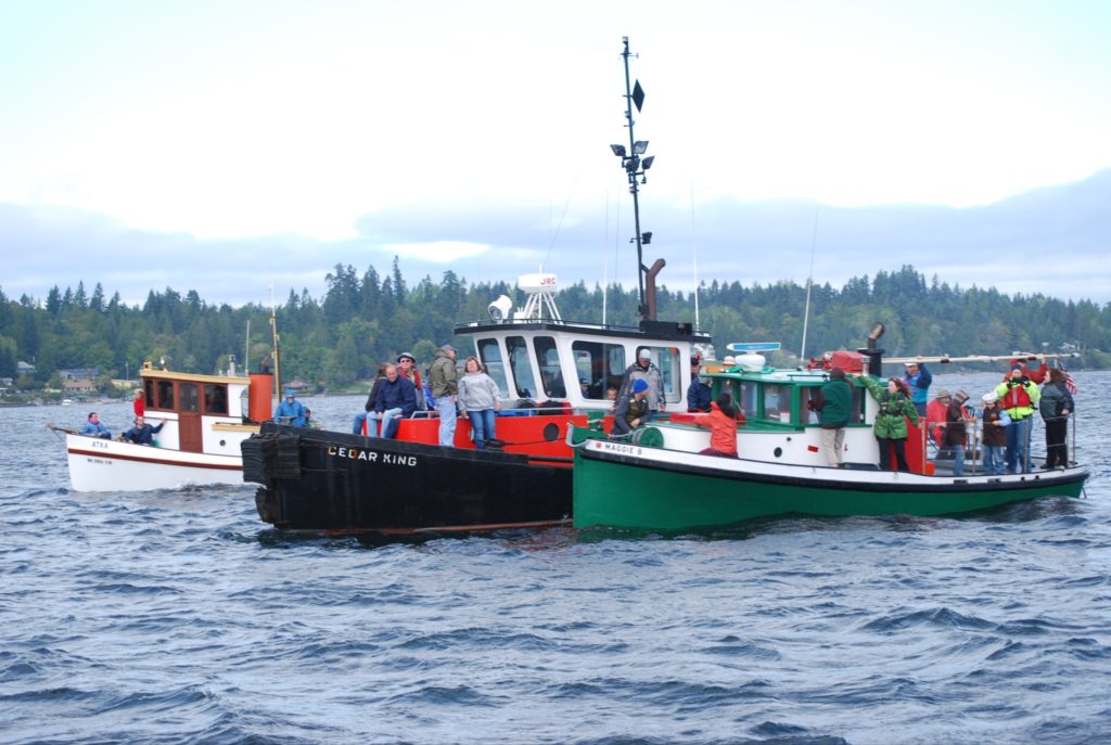 three tugboats in next to each other on the water