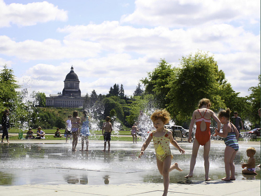 Kids playing in the Heritage Park Fountain with the capital building in the background