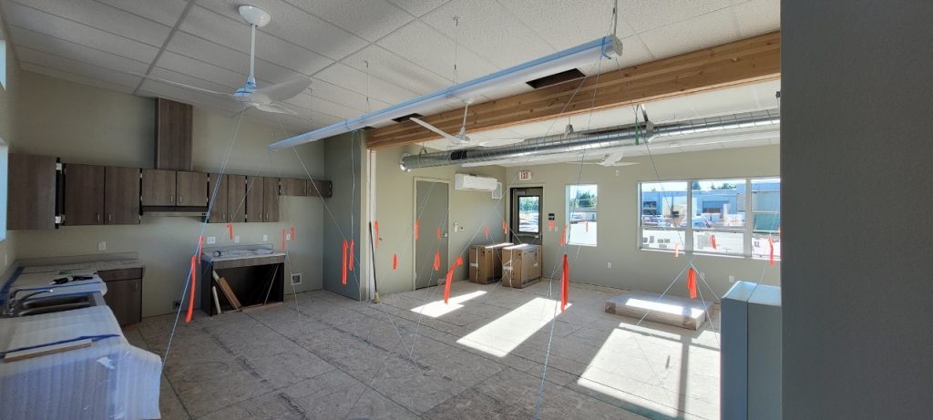 A room being worked on with construction flags, cabinets wrapped in bubble wrap and boxes on the floor