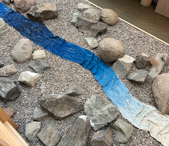 a river made of felt winds between real rocks on a table