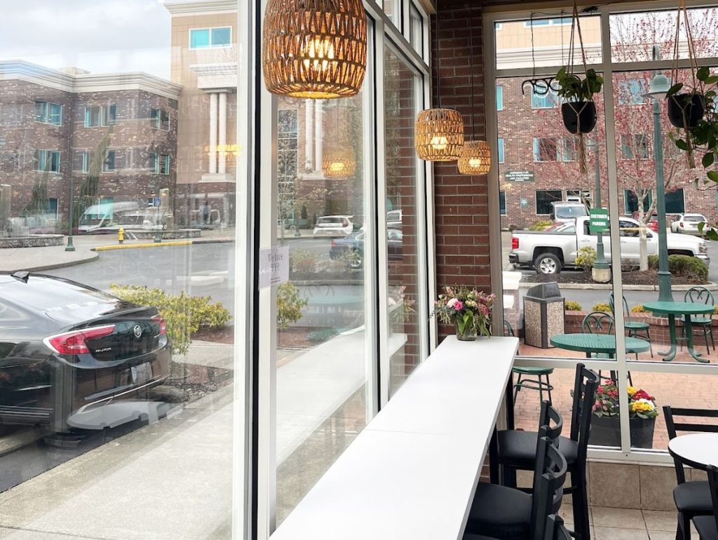 Two Sisters Coffee shop bar seating by a window with hanging lights above it