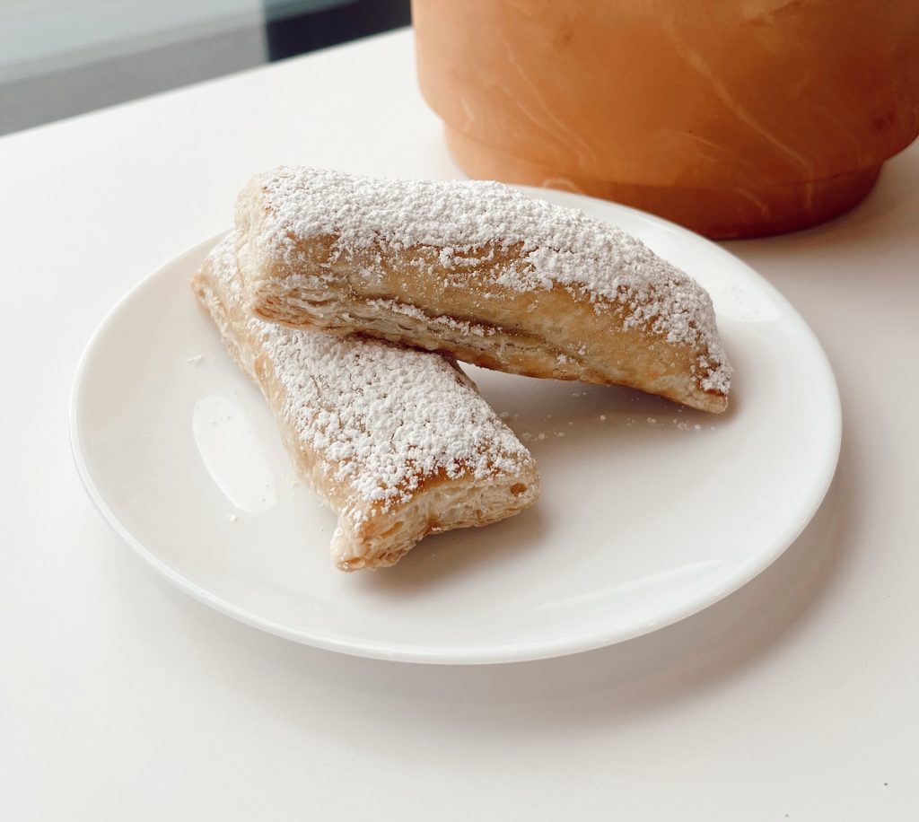 two pastries on a white plate on a white counter