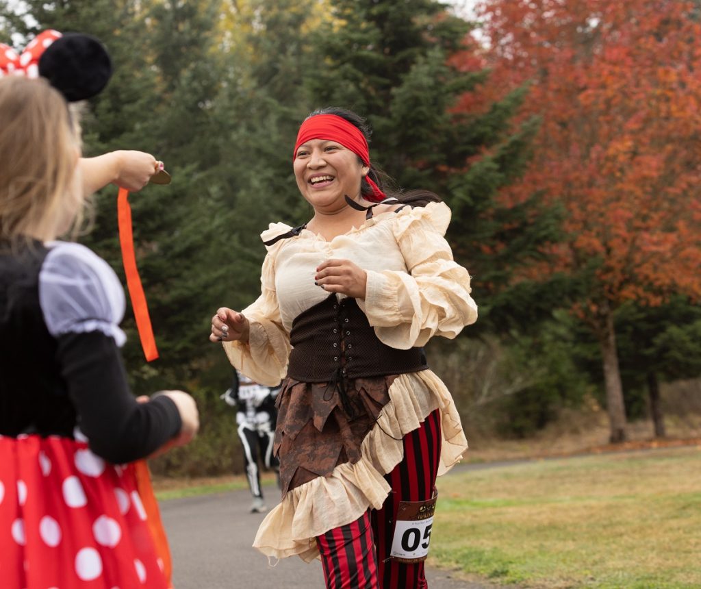 People running in a pirate and a Minnie Mouse costume