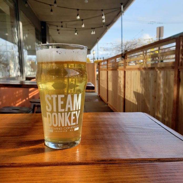 a glass of Steam Donkey beer sitting on a wooden table