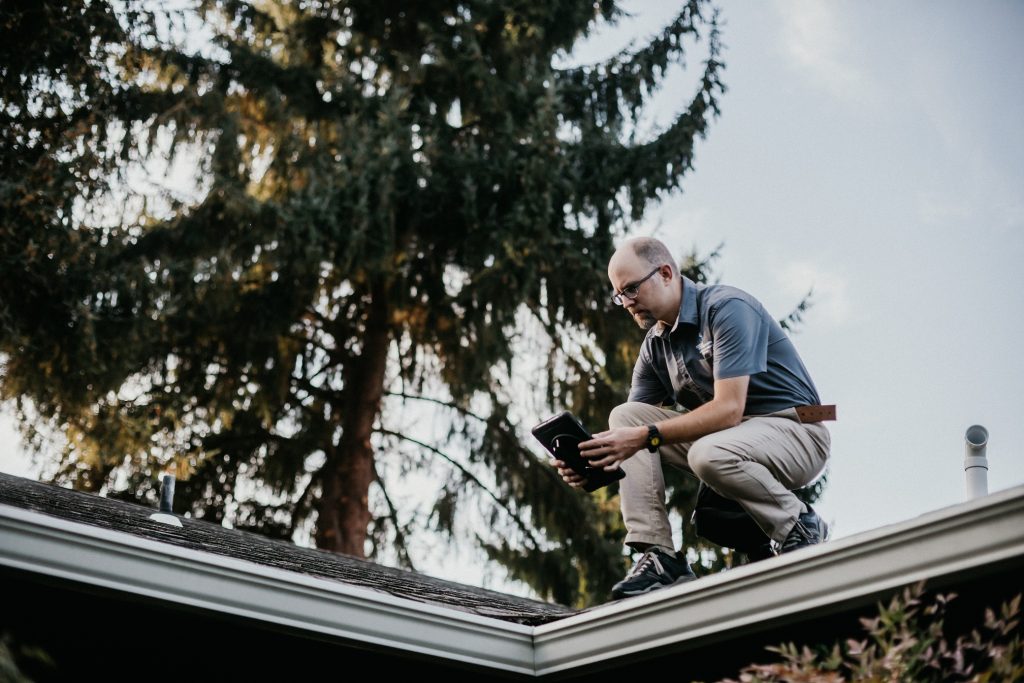 Boggs Inspection Services technician on the roof of a house