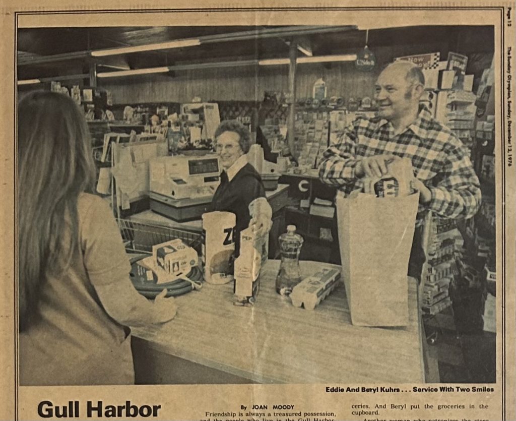 Black and white newspaper photo of Eddie and Beryl Kuhrs helping a customer at the register