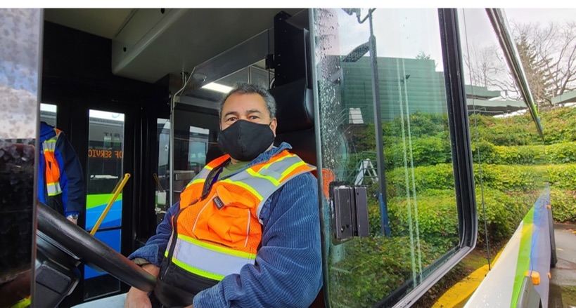 Carlos Reyes smiling from inside an Intercity Transit bus