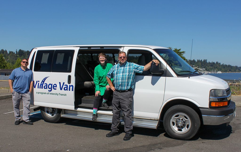 Izi LeMay, Terry Swartos and Eric Wells. standing around and inside a white Intercity Transit Village Van