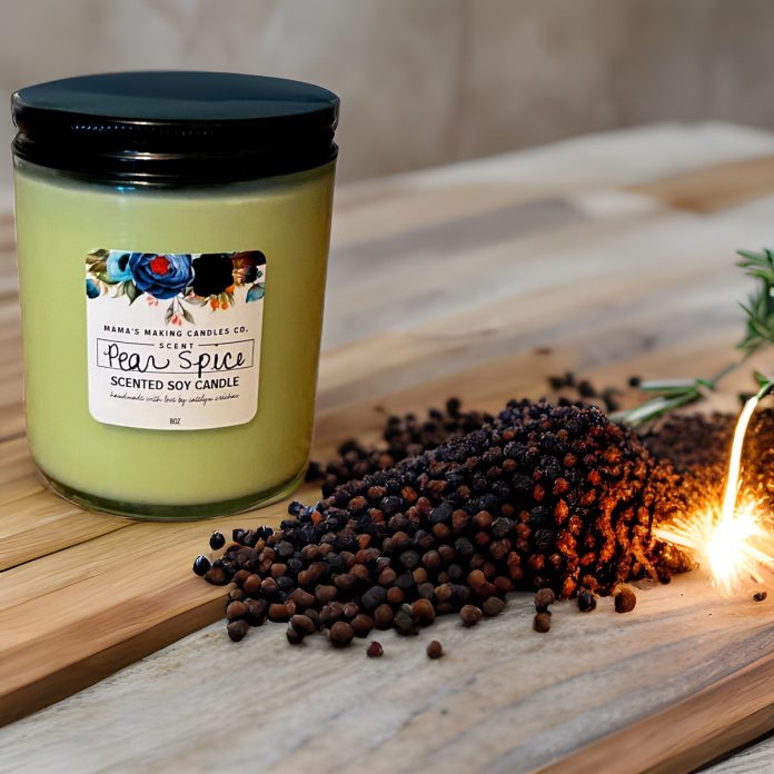 a pile of spices next to a green soy candle in jar with a label that says, 'Mama's Making Candles Co., scent, Pear Spice. Scented Soy Candle.'