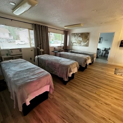 an empty classroom at Olympia School of Advanced Skincare with with massage tables with fleece blankets over them.