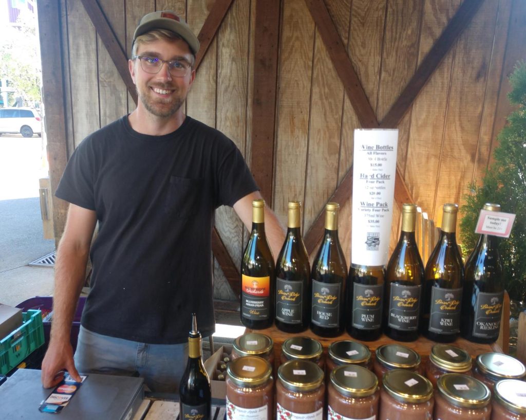 Steve Furr, of Burnt Ridge Nursery standing by jars and bottles at his Olympia Farmer's Market booth.