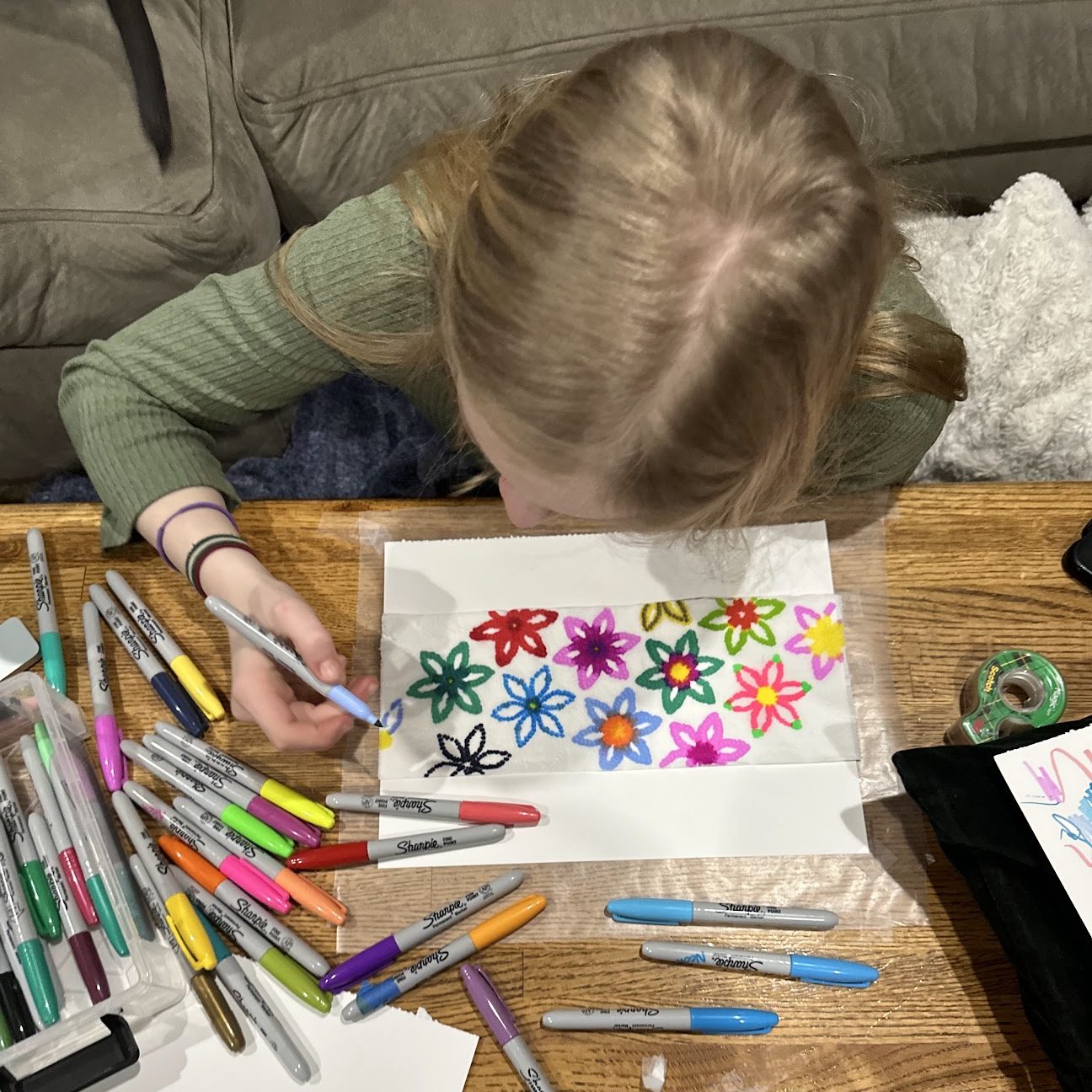 Aerial view of a girl coloring at a coffee table