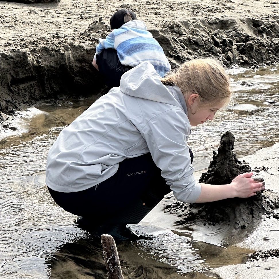 a girl and boy play in the wet sand.