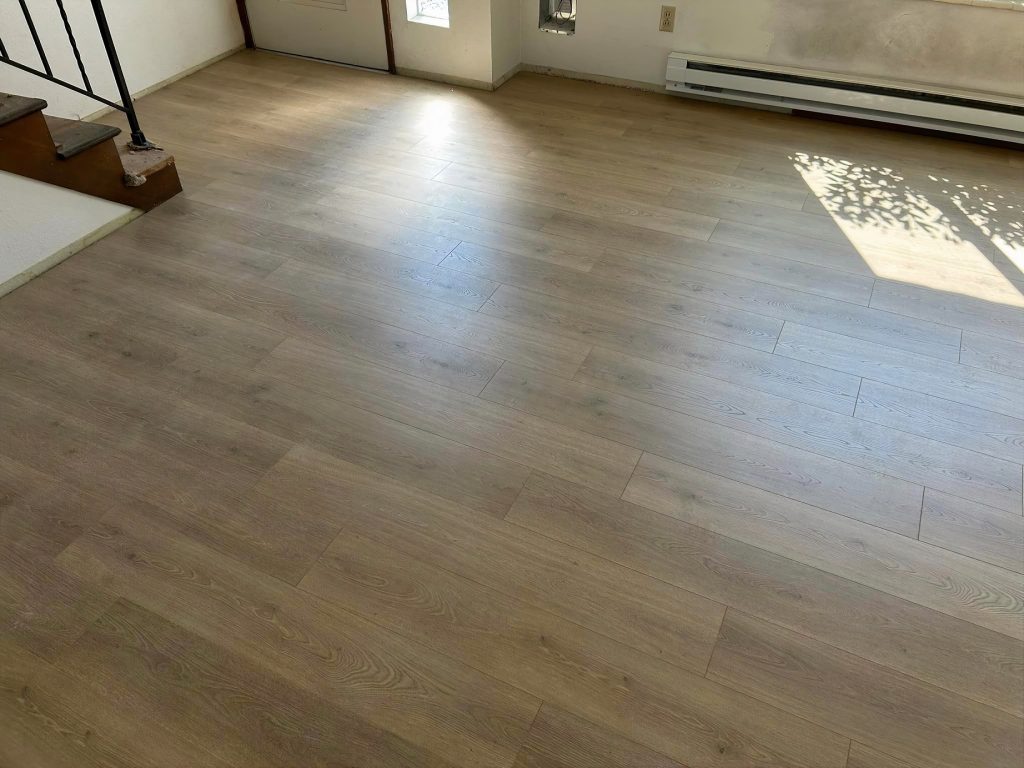 photo of an empty room with a textured vinyl plank floor that looks like wood