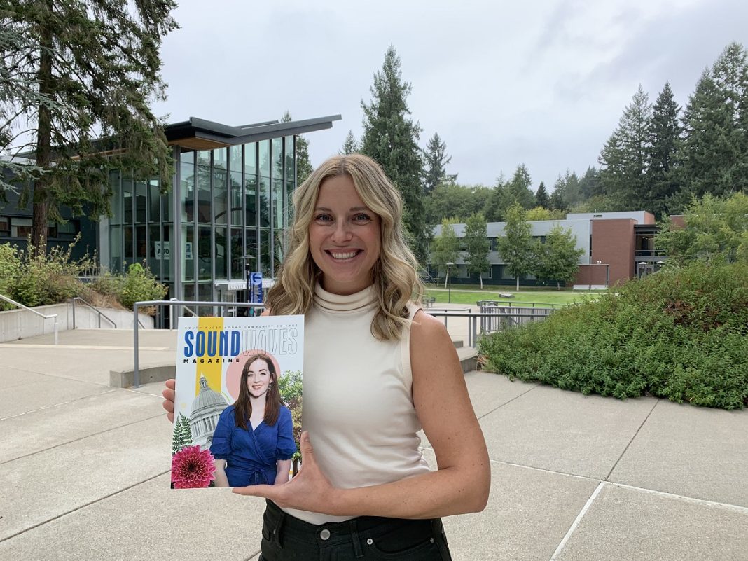 woman standing on SPSCC campus holding an issue of the Soundwaves magazine.