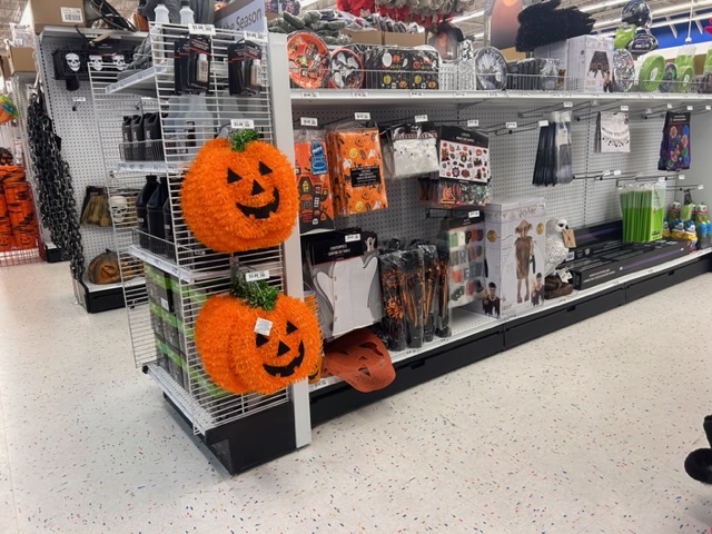 an aisleways at Party City with shelves full of an assortment of Halloween decorations.