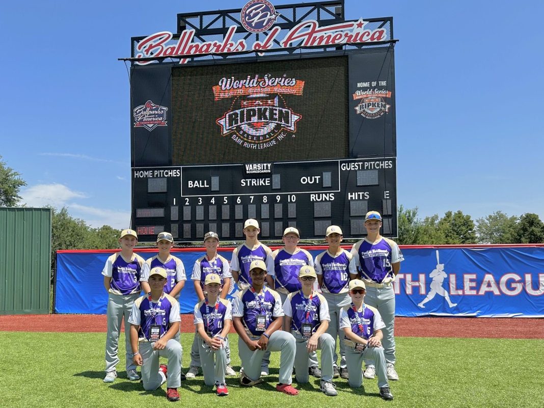 Black HIlls Youth Baseball team photo on the field with scoreboard behind them.