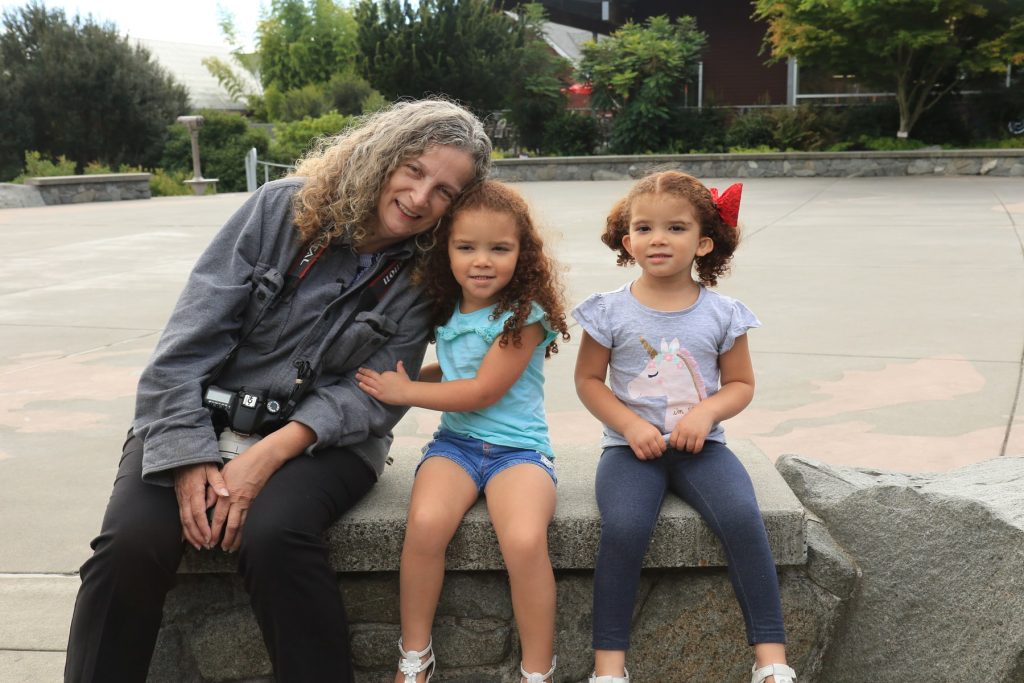 Deana Ready with two little girls, all sitting on a concrete bench