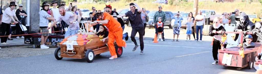 people racing caskets, some running behind them and some running next to them.