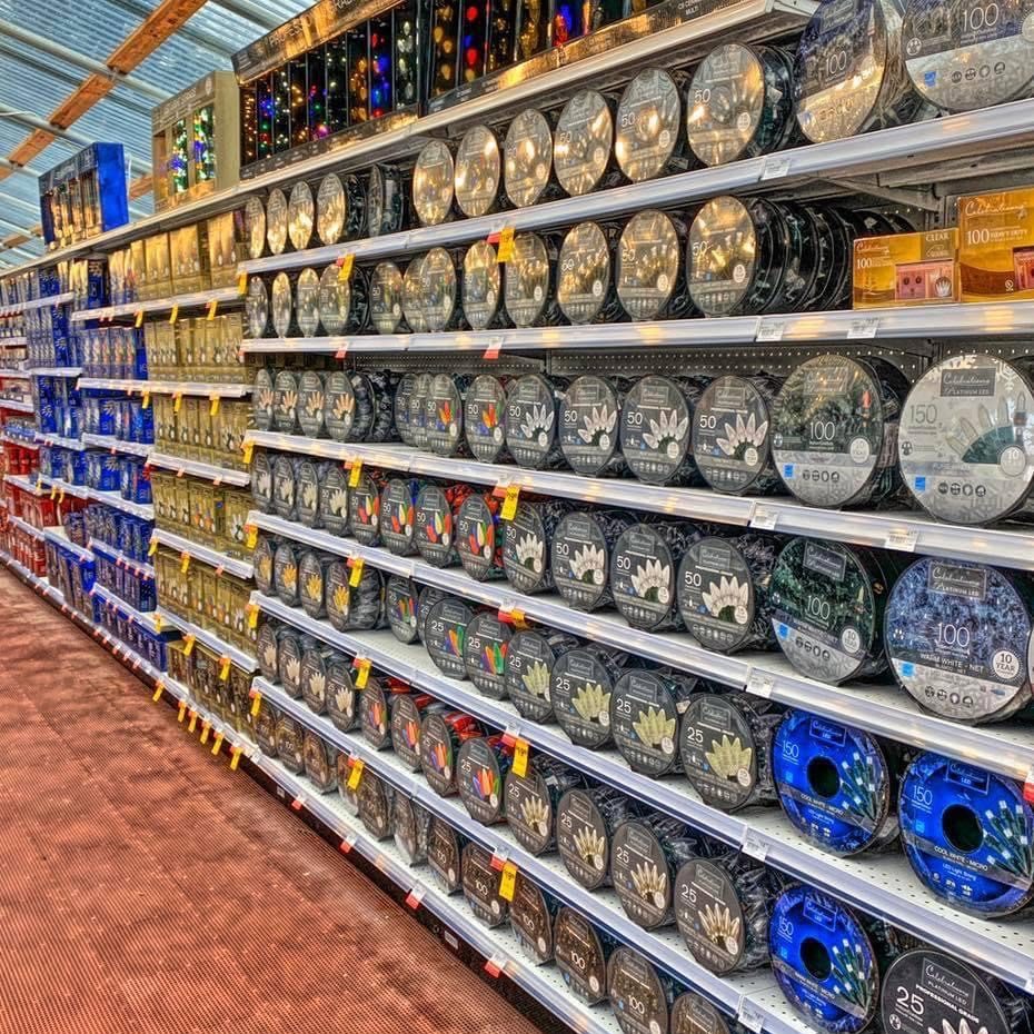 An aisle at ace hardware full of Christmas lights in boxes and reels