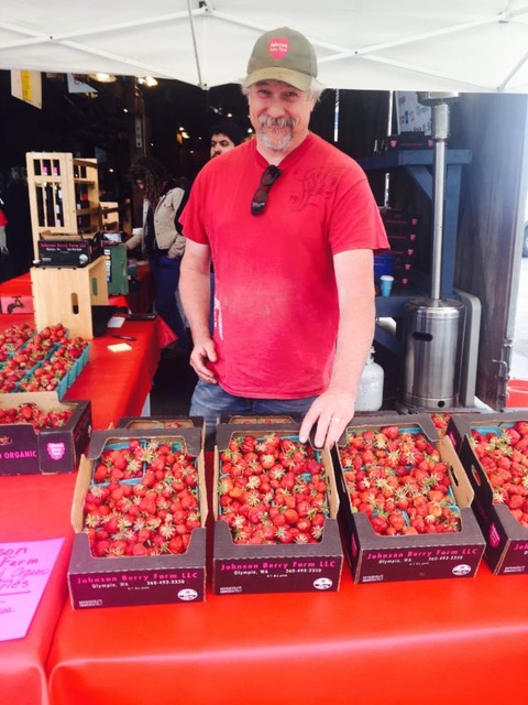 Johnson Berry Farm  owner at Olympia Farmers Market booth with boxes of strawberries