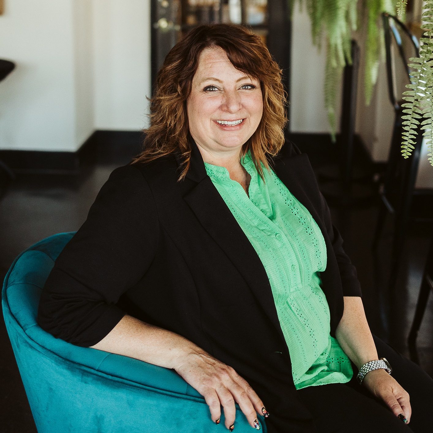 COO Jennifer Arnold sitting a chair in OlyFed