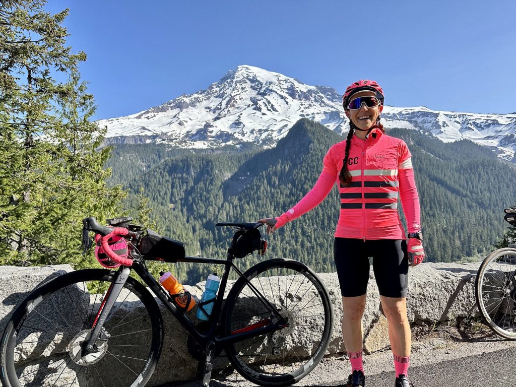 Dr. Sheila Smitherman standing next to bikes with a mountain in the background