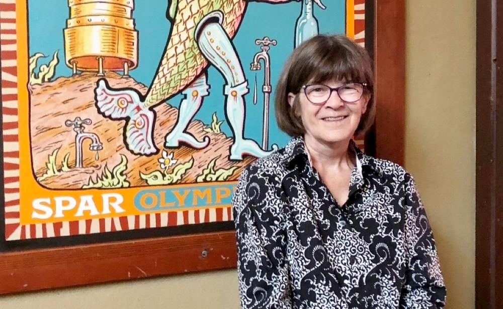 Shelley Kneip posing for a photo in front of an art piece.