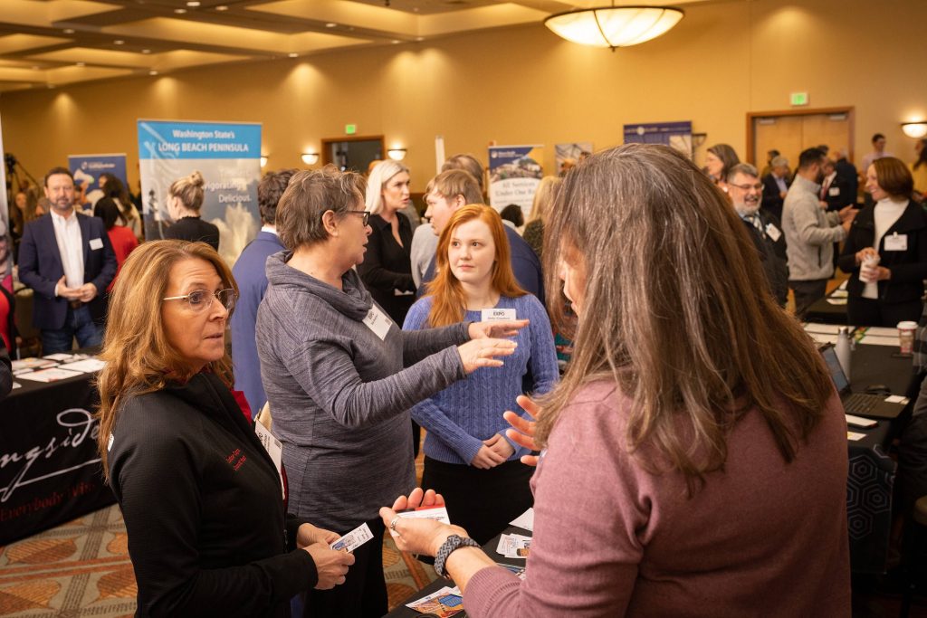 large group of people wearing name tags talking around tables