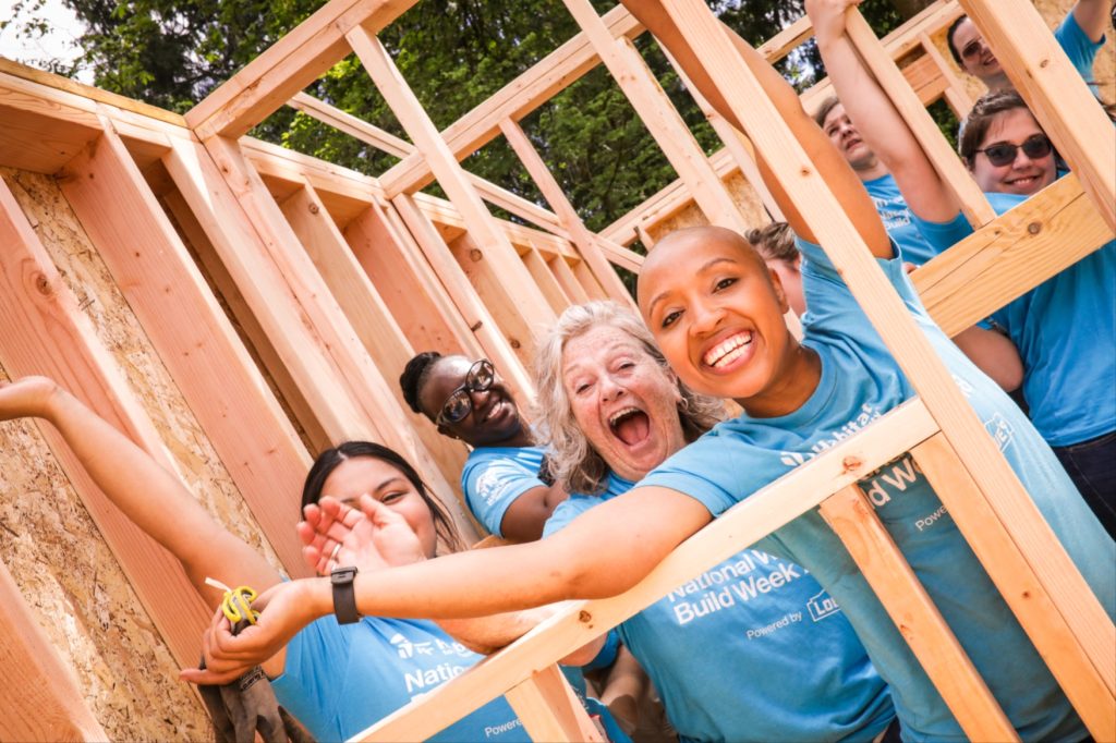 South Puget Sound habitat for humanity workers smiling inside house framing