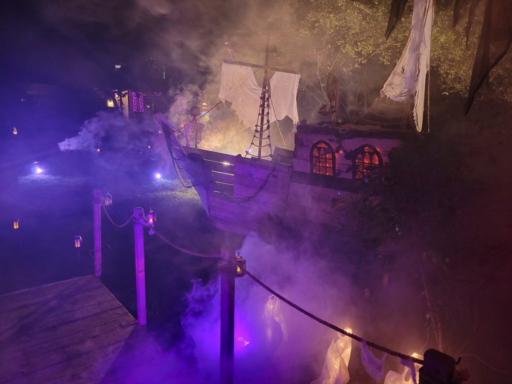 a pirate ship in a yard with fog and purple lights 