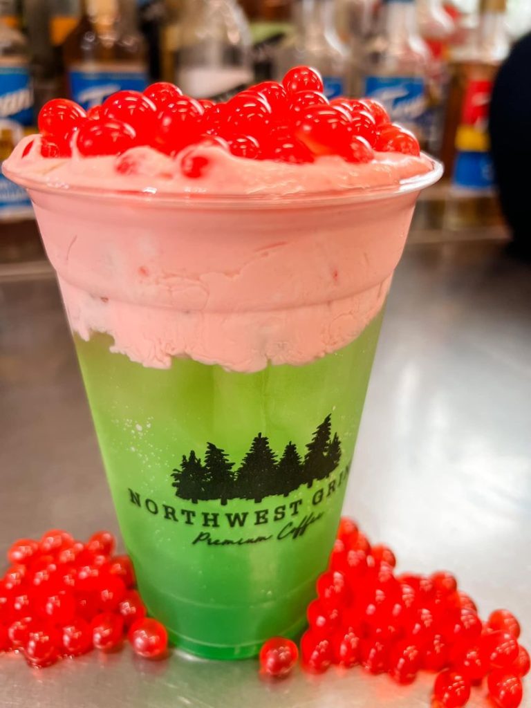 green energy drink with pink foam and pink bobbing boba pearls on top