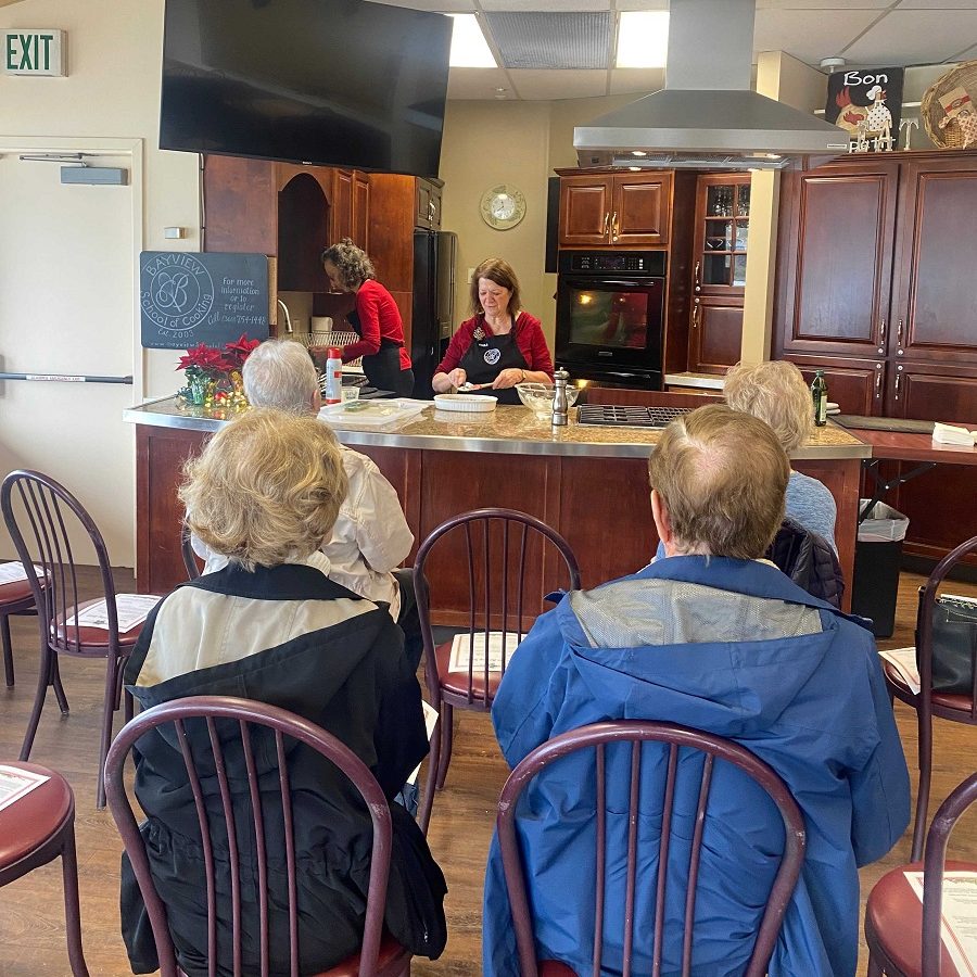 people sitting in chairs watching a cooking demonstration