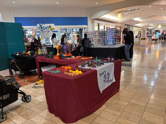 pop up tables and booths with an assortment of handmade items for sale inside the Capital Mall