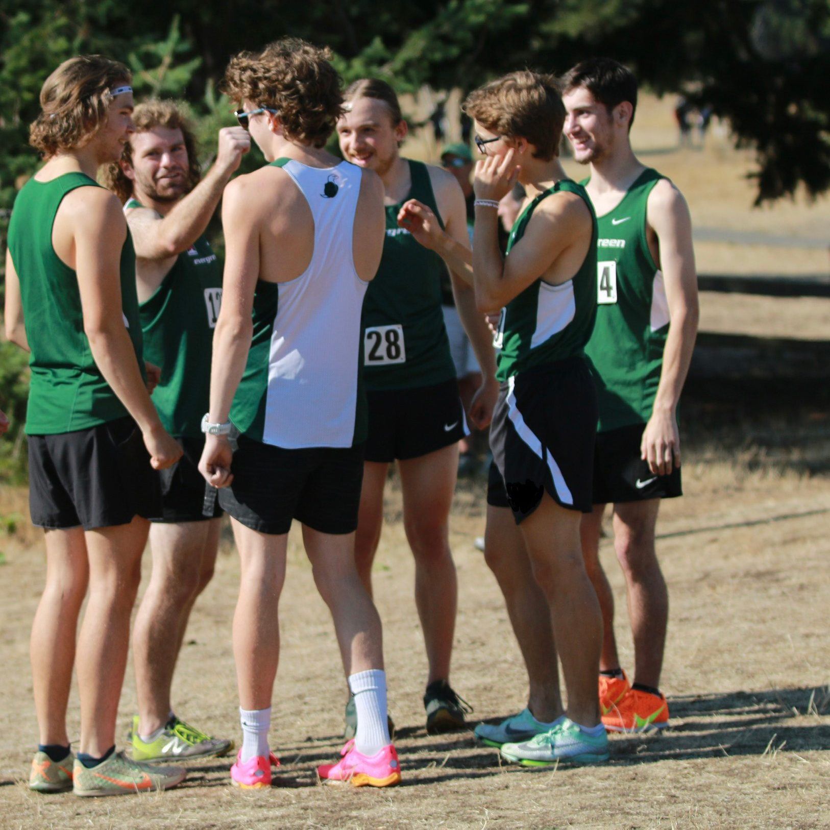 group of college cross country men in a huddle