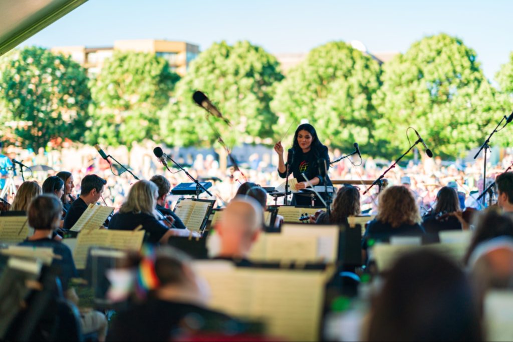 Olympia Symphony Orchestra performing outside on a sunny day