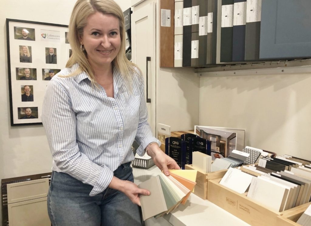 Project Developer and Interior Designer Lindsey Barnes showing samples of tile to the camera